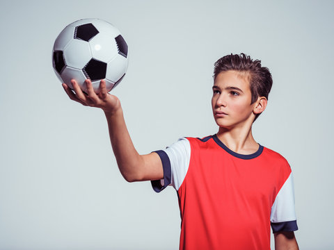 Photo of teen boy in sportswear holding soccer ball