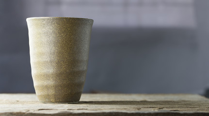 Japanese tea cup on Top of natural wooden table with detailed textured look clean, texture on glass, home made product.