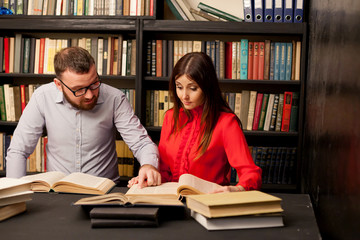 a man with a woman in the library prepared for the exam read books