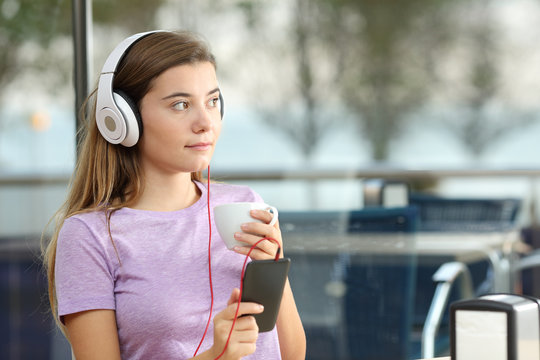 Serious teenager listening to music in a bar