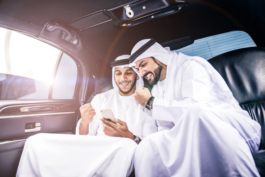 Two arabic businessmen inside their company limousine