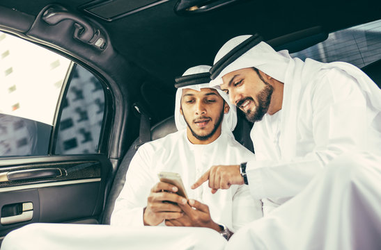 Two arabic businessmen inside their company limousine