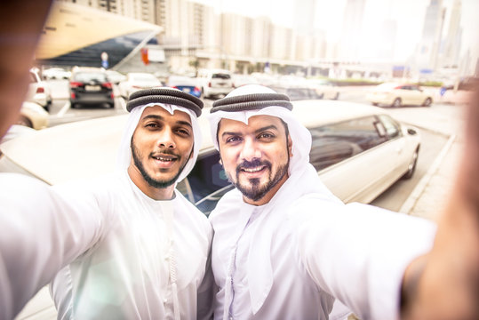 Two arabian businessmen taking selfie near the limousine