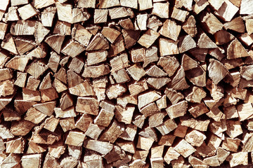 Stack of natural firewood in preparation for the winter and used for camp fires, fireplaces and home heating. Chopped and piled wood background texture.
