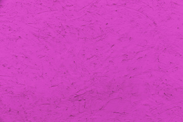 Pink color stucco coarse facade wall made of cement as an empty rustic background texture space.