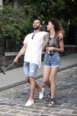 Cheerful young couple walking on urban street
