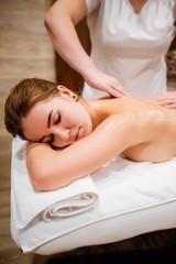 Masseur woman back rubs girls massage oil in preparation for the procedure