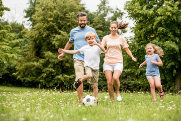 Familie und Kinder spielen Fußball im Garten