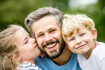 Glücklicher Vater mit zwei Kindern lacht