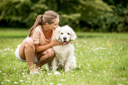 Frau mit Golden Retriever Hund im Garten