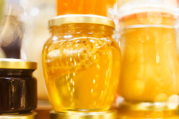 Holiday fair. Jars of honey glowing in garlands of lighting bulbs.