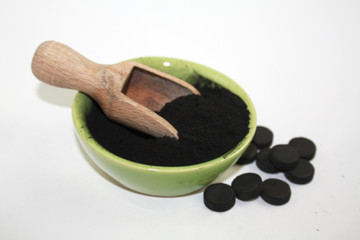 Charcoal powder and activated carbon pills photo concept image