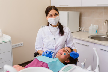 Beautiful girl with dental braces at the reception at the dentist.