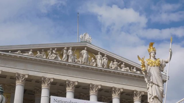 Time lapse style of moving clouds over top of parliament building and Athena Fountain in Vienna, Austria.
