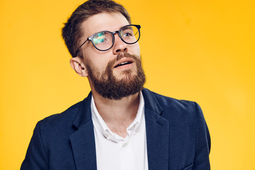 Obraz premium Businessman in glasses with a beard on a yellow background