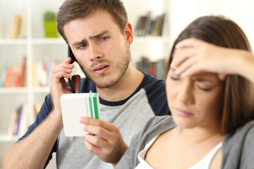 Husband helping his sick wife calling doctor