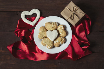 Cookies in the form of hearts, a gift and heart handmade. On wooden background. Top view, flat lay