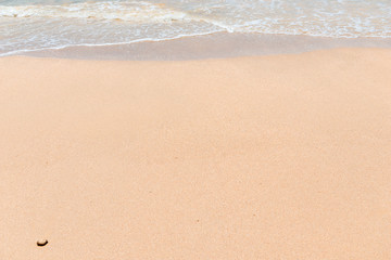 Fototapeta na wymiar background wet sand on the beach and sea wave close-up