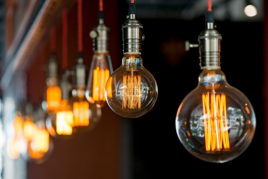 light bulb hanging from the ceiling in a retro style closeup in darkness