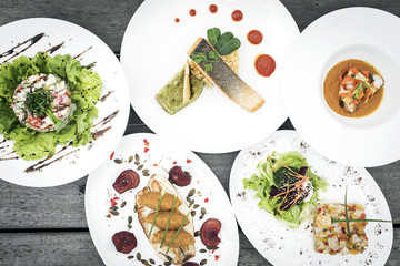 mixed modern gourmet fusion food dishes on table