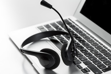 call center support concept. headset on keyboard computer laptop