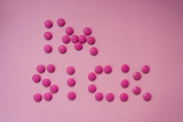 Pink pills on a pink background. The words 