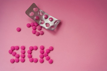 Pink pills on a pink background.  The word 