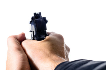 Close-up of man hands holding a gun that is in ready position to shoot on light background