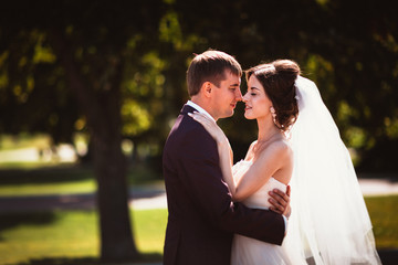 young couple groom and the bride on the park background.