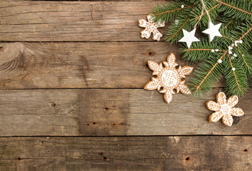 Greeting card with decor gingerbread cookies snowflakes, fir tree branch on old wooden background. Overhead of Christmas New Year holiday background. Top view.