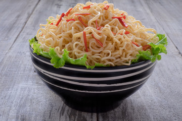 Instant noodle in the bowl on wooden background