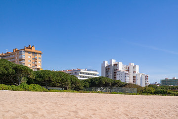 View from the beach on the coastal hotels of the Costa Brava framed with green bushes