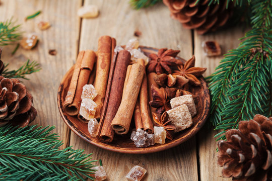 Christmas spices in plate on wooden rustic table. Anise star, cinnamon sticks and brown sugar.