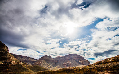 Beautiful rocky canyon mountain landscape with cloudy sky with sun ray flare