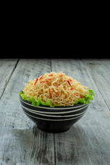 Instant noodle in the bowl on wooden background
