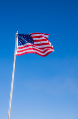 USA American Flag waving with clear blue sky background in Veritcal view