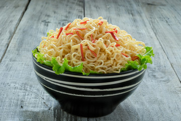 Instant noodle in the bowl on wooden background