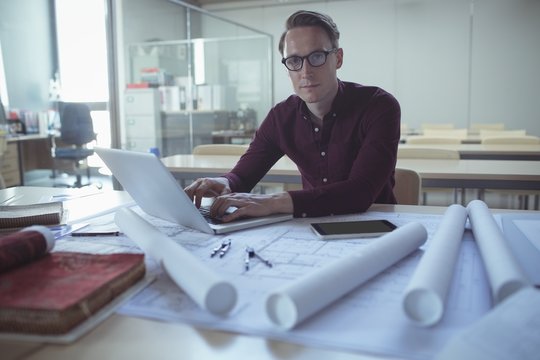  Architect using laptop at table