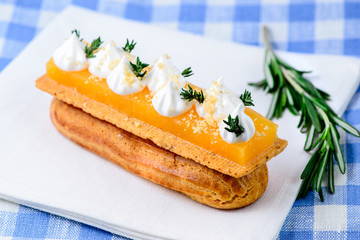 Traditional French dessert. Delicious eclair dessert with cream on tablecloth, selective focus