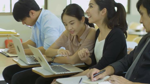 Asian College students are discussing and using labtop in classroom
