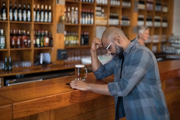 Depressed man standing at counter