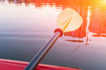 Closeup of oar paddle in the background of water. Toned, selective focus