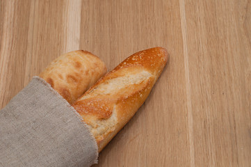 Two baguettes wrapped in a linen napkin
