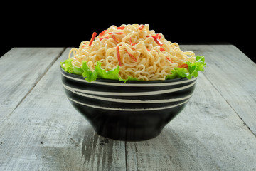 Instant noodle in the bowl on wooden background