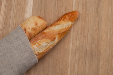 Two baguettes wrapped in a linen napkin