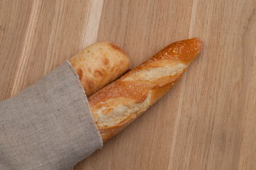 Two baguettes wrapped in a linen napkin