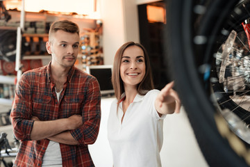 Obraz premium A girl consultant shows the buyer in a bicycle store.
