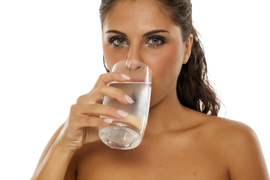 a young woman drinks cold water from the glass