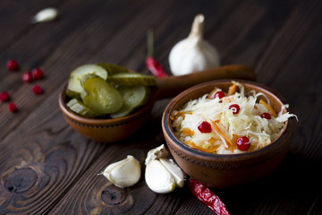 sauerkraut with cranberries and vegetables : garlic, cucumber, chili peppers on the table