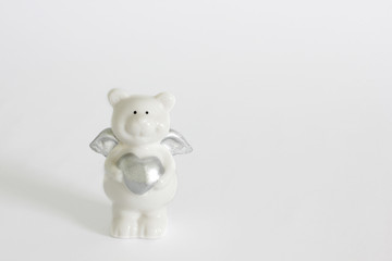 porcelain teddy bear with a heart on a white background. love